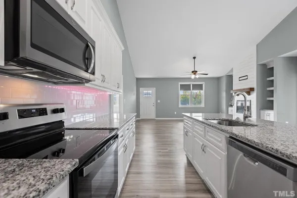 a kitchen with stainless steel appliances granite countertop a sink and stove