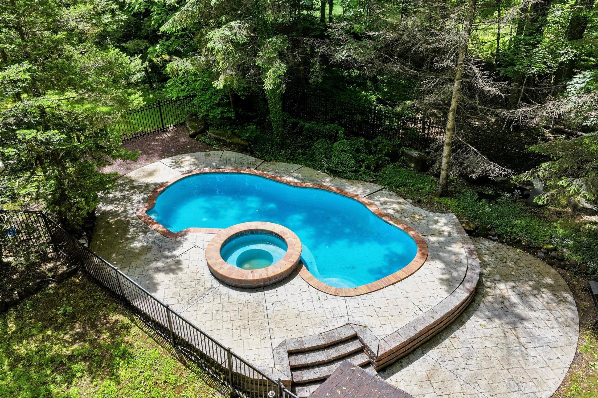 607 Kulp Road Perkiomenville, PA 18074 - Photo 35 of 39 Serene pool nestled in lush greenery.