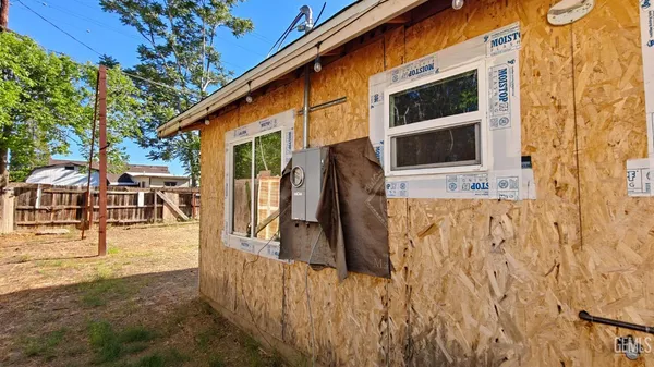 a view of house with backyard and furniture