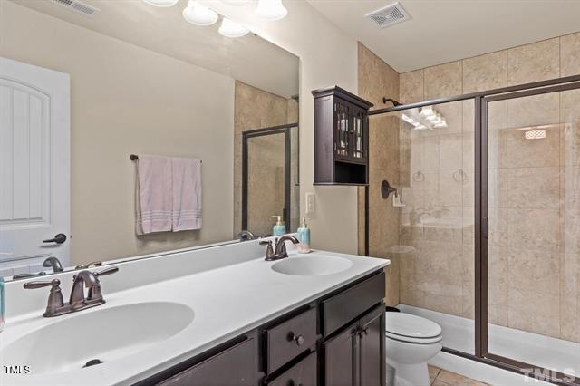 2652 Averon Drive Fuquay-Varina, NC 27526 - Photo 4 of 11 a bathroom with a sink toilet double vanity and shower