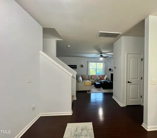 a view of a livingroom with furniture hardwood floor and a hallway