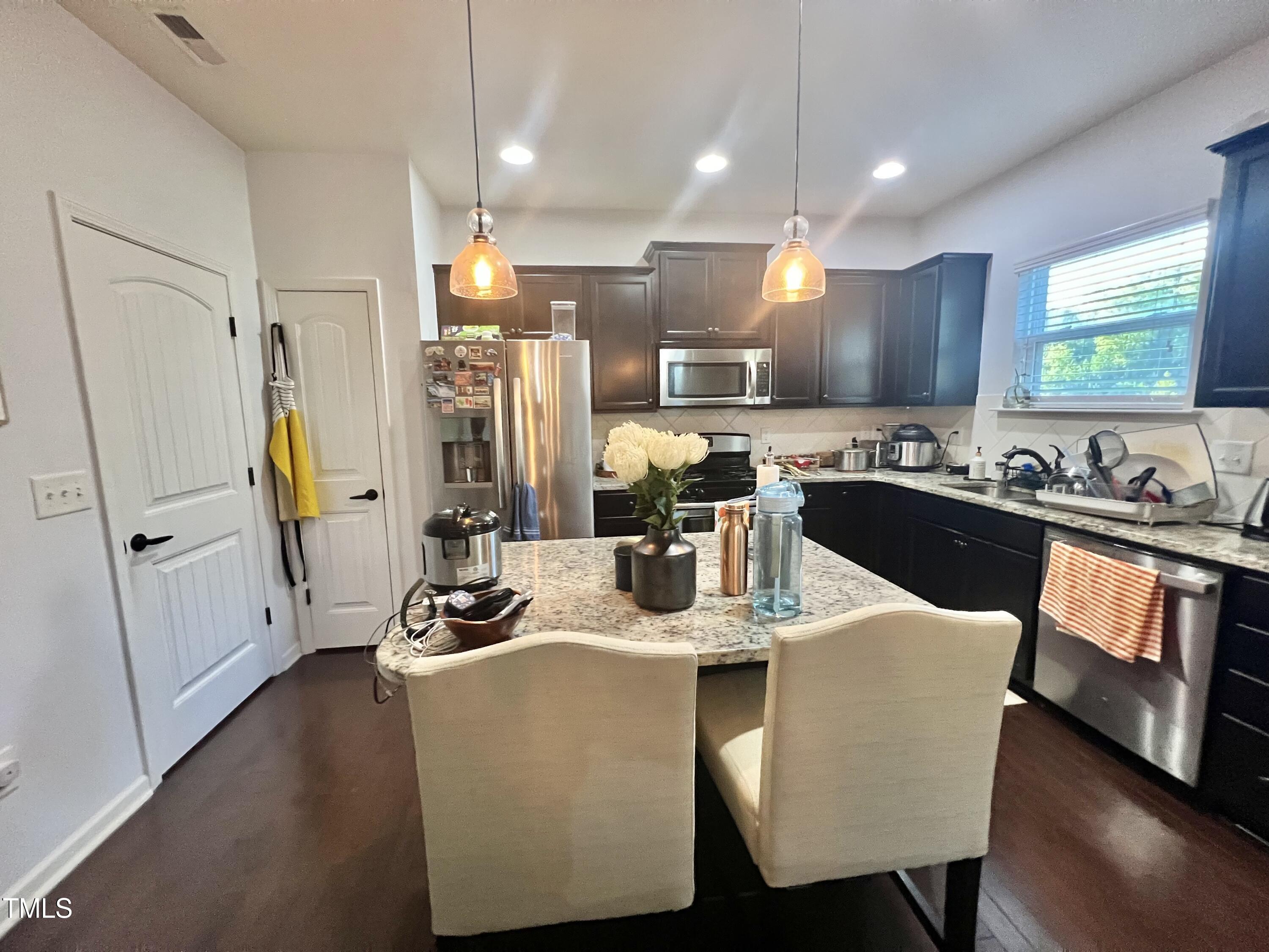 2652 Averon Drive Fuquay-Varina, NC 27526 - Photo 7 of 11 a kitchen with stainless steel appliances granite countertop sink stove refrigerator and cabinets