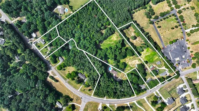 a front view of a house with a garden and trees