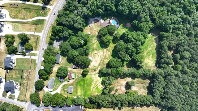 an aerial view of a house with swimming pool and outdoor seating