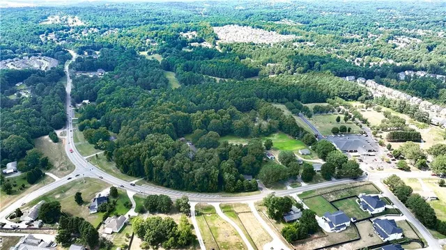 an aerial view of residential house with outdoor space and trees all around