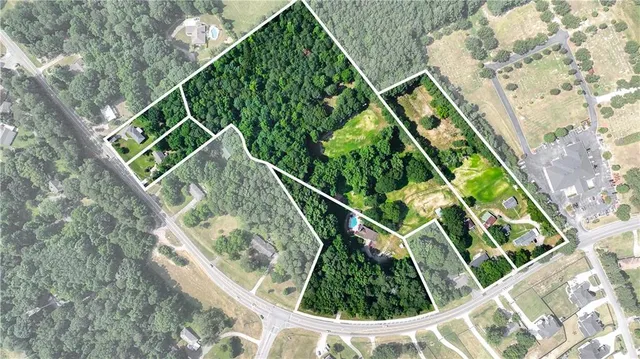 a front view of a house with a garden and trees