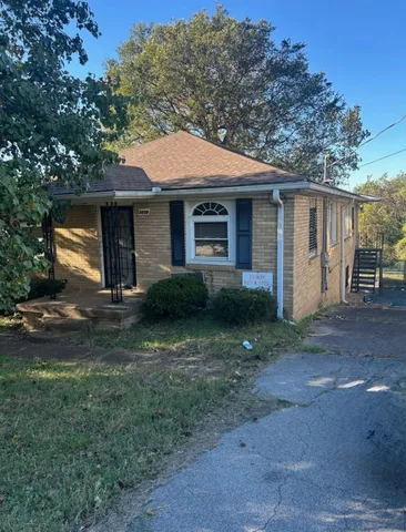 a front view of a house with yard and trees
