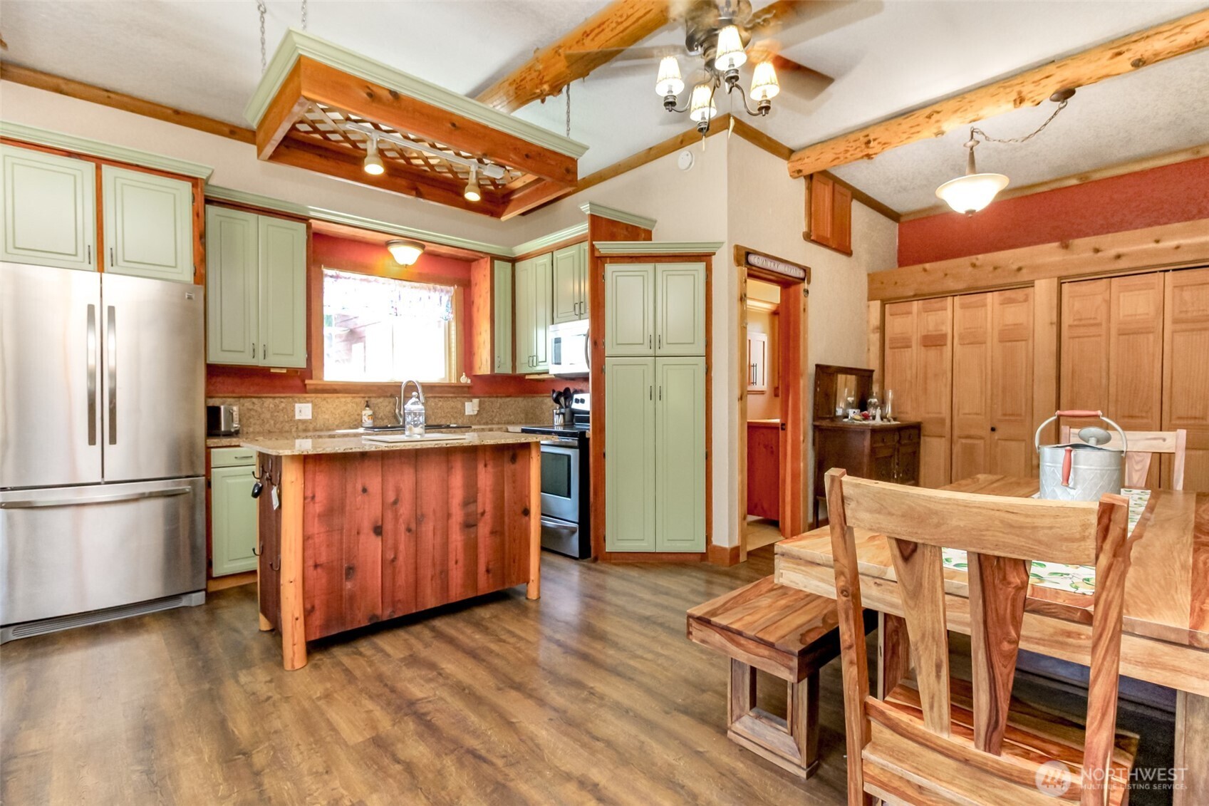 3116 Harts Lake Road South Roy, WA 98580 - Photo 10 of 39 a kitchen with stainless steel appliances granite countertop a refrigerator a sink dishwasher a stove and a dining table with wooden floor