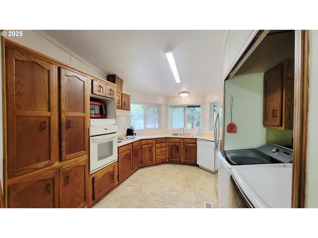 a kitchen with stainless steel appliances kitchen island granite countertop a refrigerator and cabinets