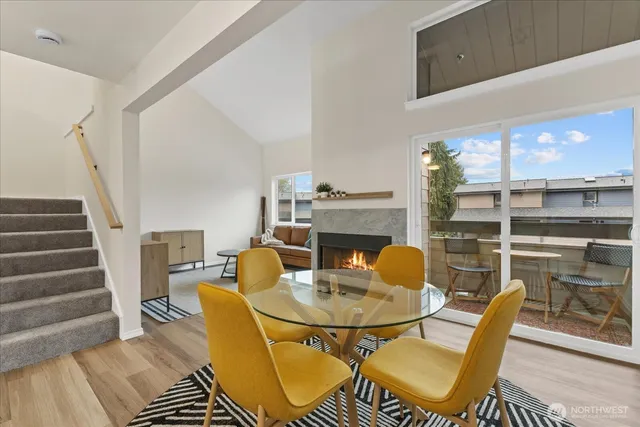 a dining room with furniture a fireplace and wooden floor