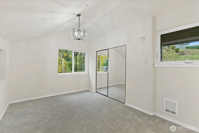 an empty room with windows and closet