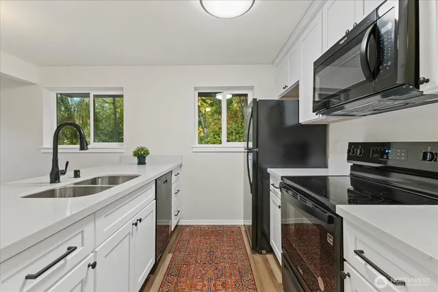 a kitchen with stainless steel appliances a sink stove and microwave