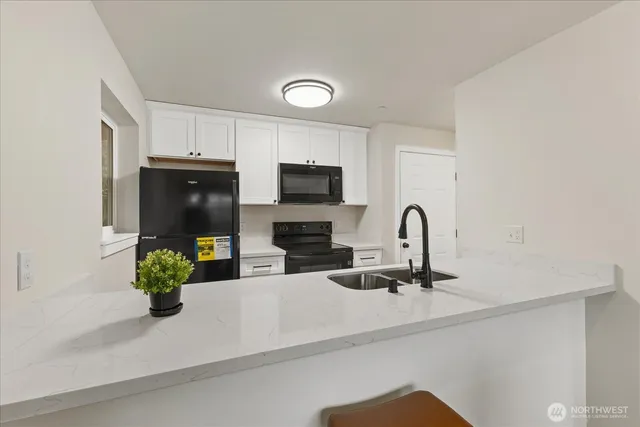 a kitchen with a sink stainless steel appliances and a counter top space