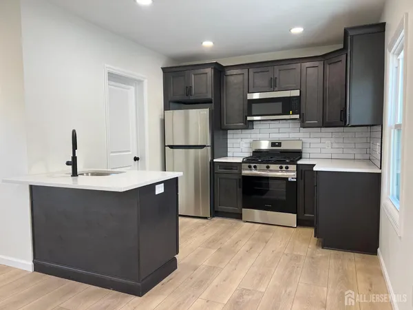 a kitchen with stainless steel appliances a sink stove and refrigerator