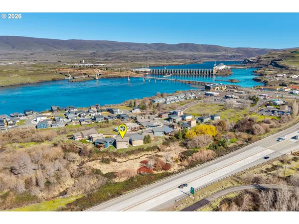 a view of empty room with wooden floor and windows