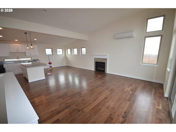 a kitchen with stainless steel appliances granite countertop a refrigerator a stove top oven a sink dishwasher and a refrigerator with wooden floor