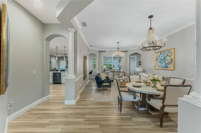 a dining room with furniture a chandelier and wooden floor