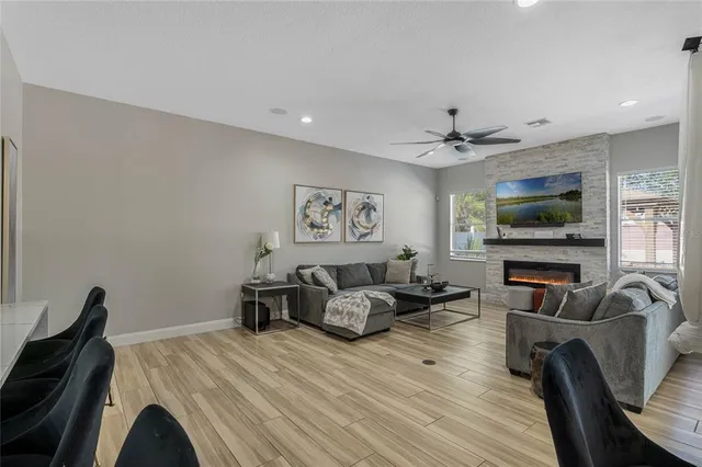 a living room with furniture a flat screen tv and wooden floor