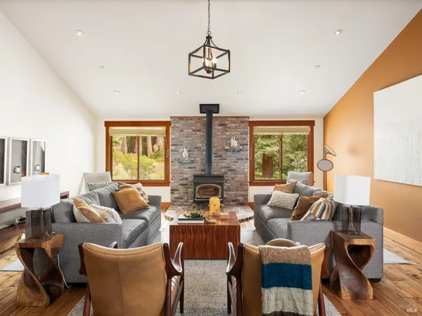 a living room with fireplace furniture and a large window