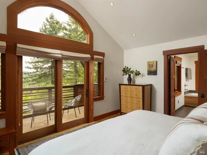 a bedroom with a bed and large windows