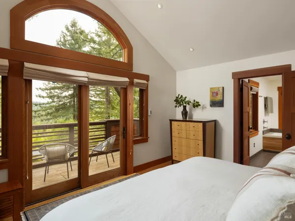 a bedroom with a bed and large windows