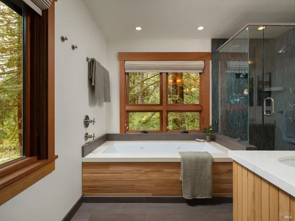 a spacious bathroom with a tub and a large window
