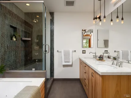 a bathroom with a double vanity sink a mirror and shower
