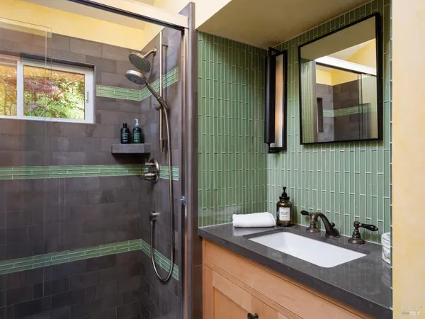 a bathroom with a sink a mirror and a shower