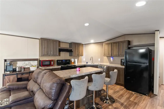 a kitchen with stainless steel appliances granite countertop a sink refrigerator and cabinets