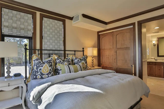 a bedroom with a bed and two mirror