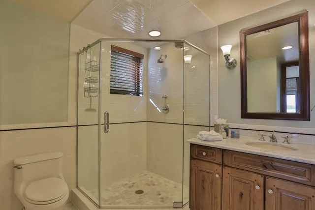 a bathroom with a granite countertop sink toilet and shower