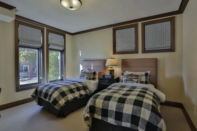 a bedroom with two beds and windows