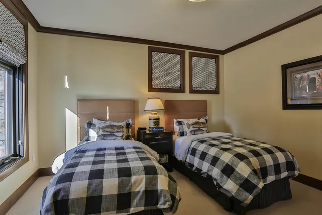 a bedroom with two beds and painting on the wall