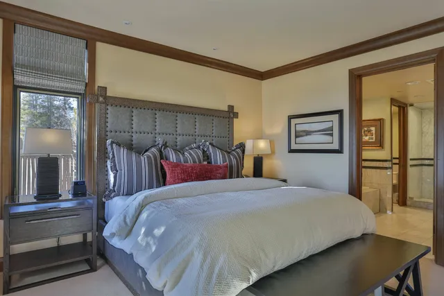 a bedroom with a large bed and a chandelier