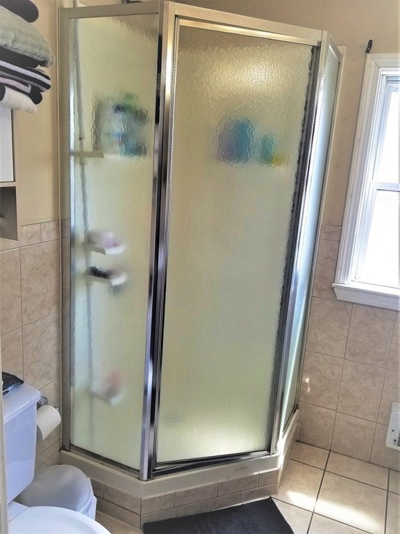 12 Linden Circle Somerville, MA 02143 - Photo 17 of 24 a bathroom with a glass shower door and a window