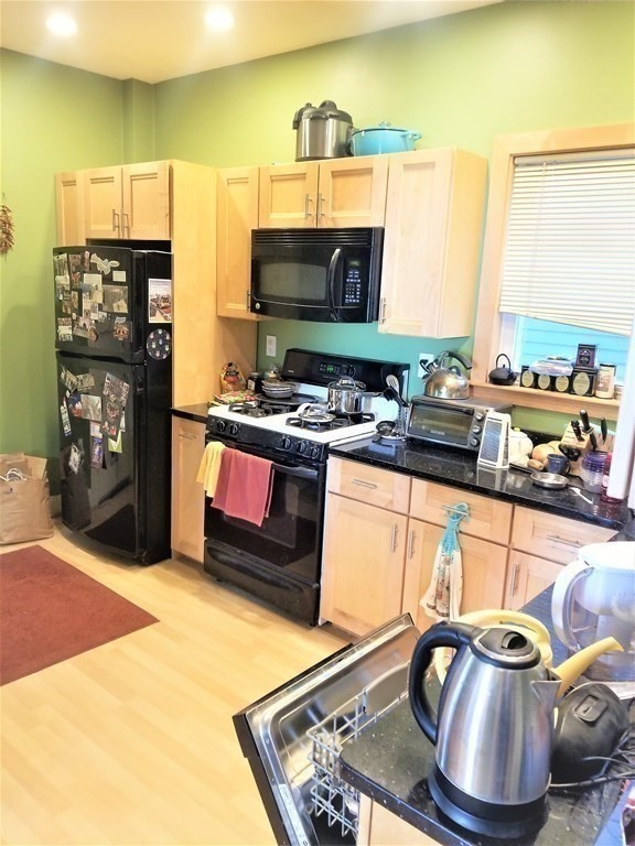 12 Linden Circle Somerville, MA 02143 - Photo 6 of 24 a kitchen with stainless steel appliances granite countertop a sink and a stove