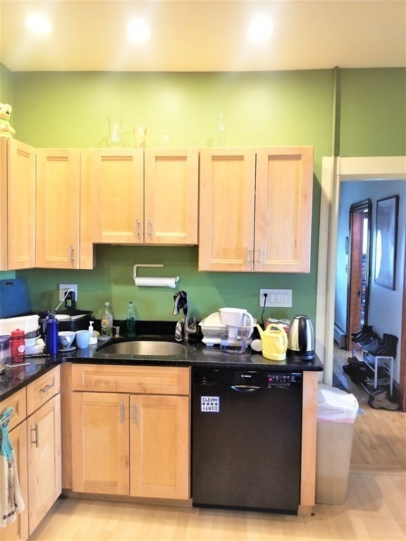 12 Linden Circle Somerville, MA 02143 - Photo 7 of 24 a kitchen with stainless steel appliances granite countertop a sink a stove and a microwave