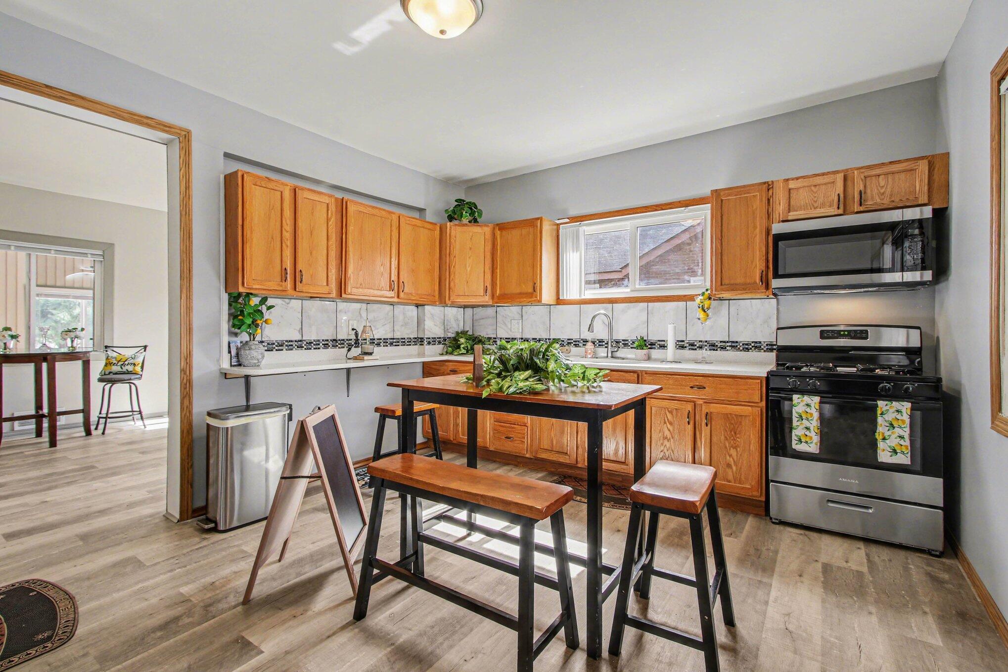 5962 Park Place Hammond, IN 46320 - Photo 14 of 20 a kitchen with a table chairs microwave and cabinets