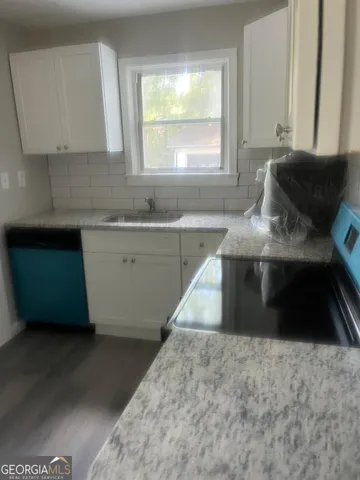 a kitchen with granite countertop a sink and a stove