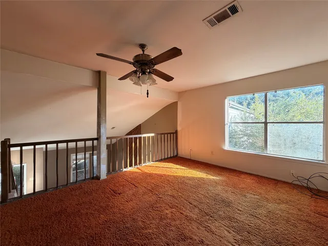 a view of a livingroom with a ceiling fan and a window