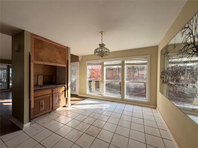 a view of an empty room with a fireplace and a window