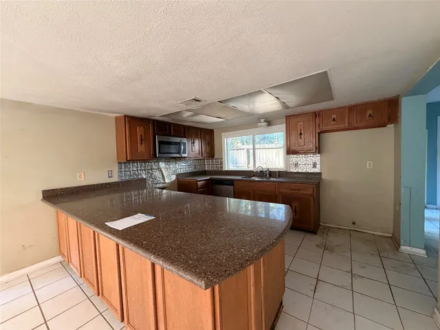 a kitchen with stainless steel appliances granite countertop a sink dishwasher and a refrigerator