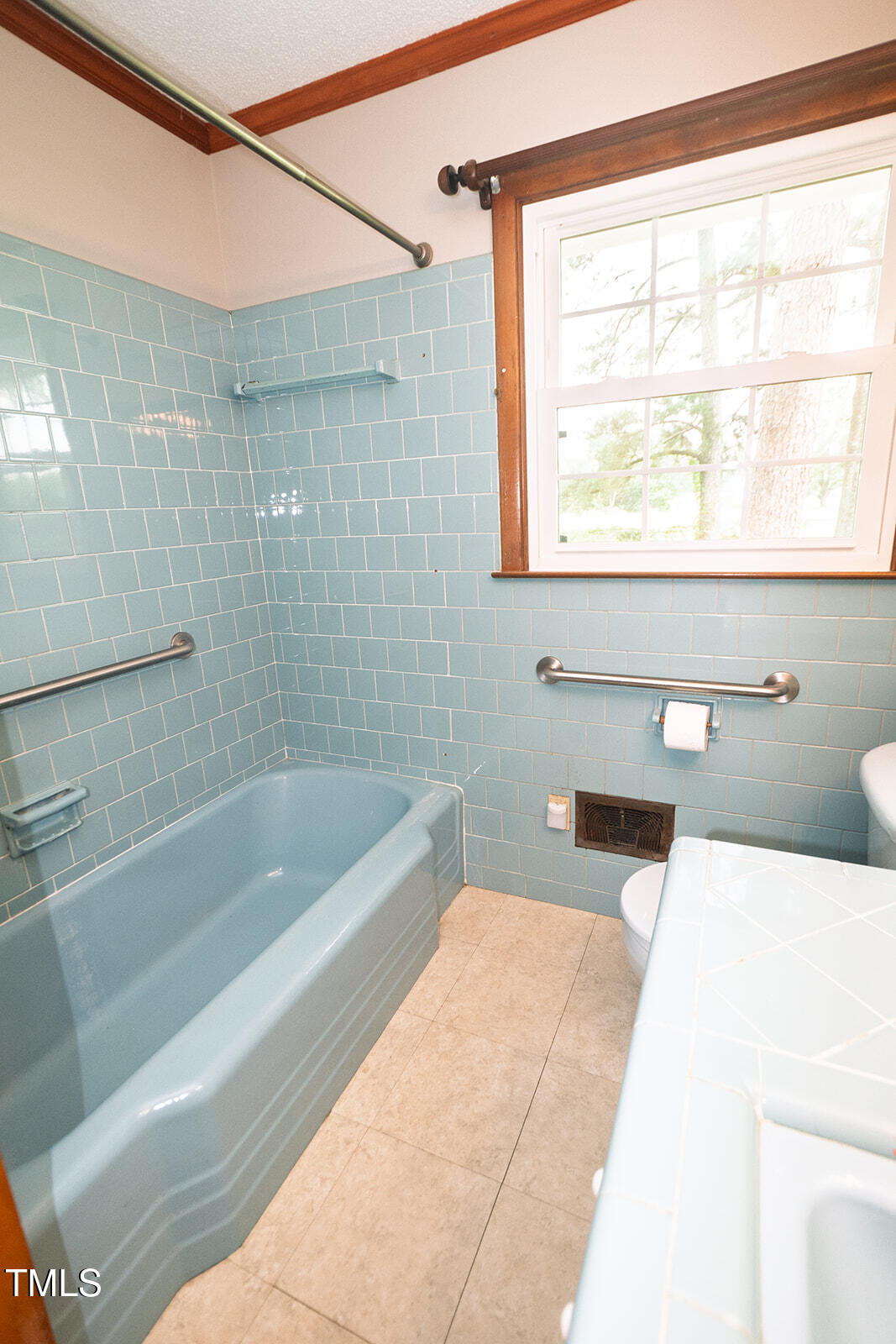 205 North Augusta Avenue Benson, NC 27504 - Photo 19 of 22 a bath tub sitting next to a white sink and a toilet