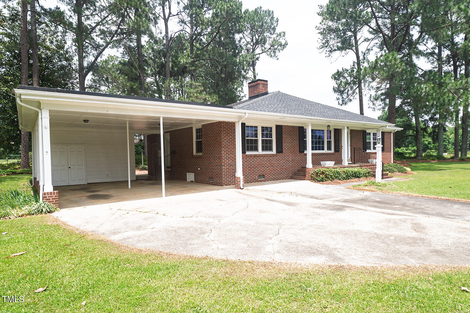 205 North Augusta Avenue Benson, NC 27504 - Photo 3 of 22 a front view of a house with a yard and potted plants