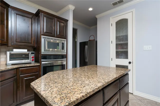 a kitchen with stainless steel appliances granite countertop a sink stove and microwave
