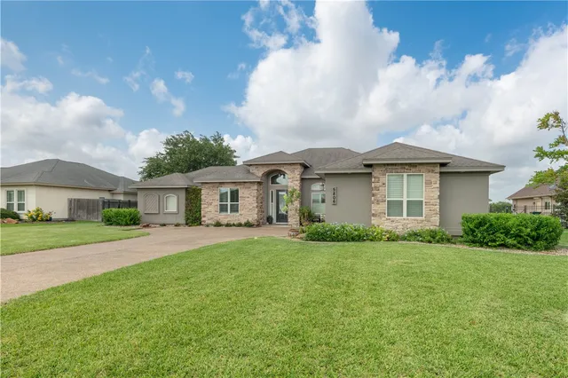 a front view of a house with a garden and yard