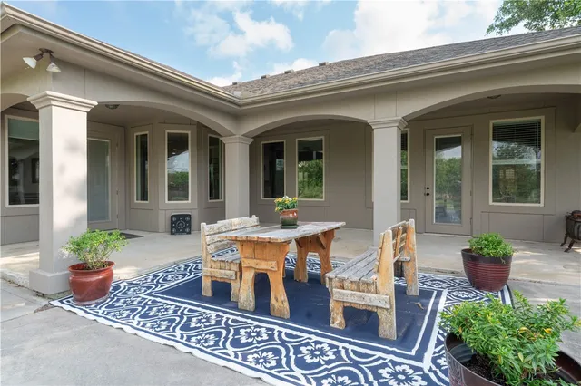 a view of a patio with table and chairs with wooden floor and fence