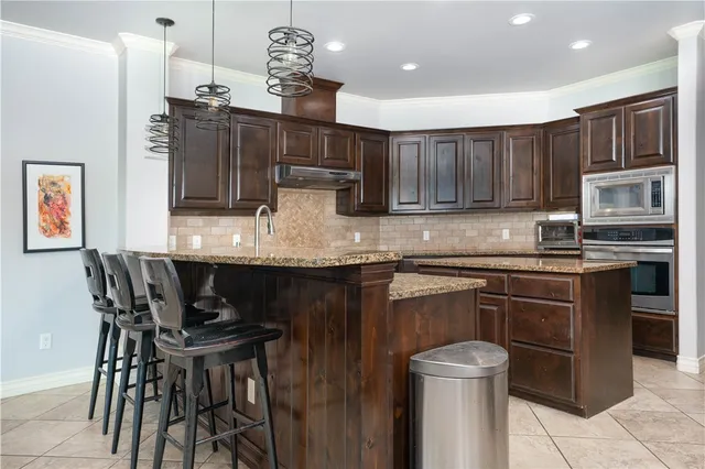 a kitchen with stainless steel appliances granite countertop a sink stove and microwave