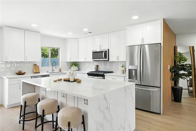 a kitchen with stainless steel appliances a refrigerator stove microwave and cabinets