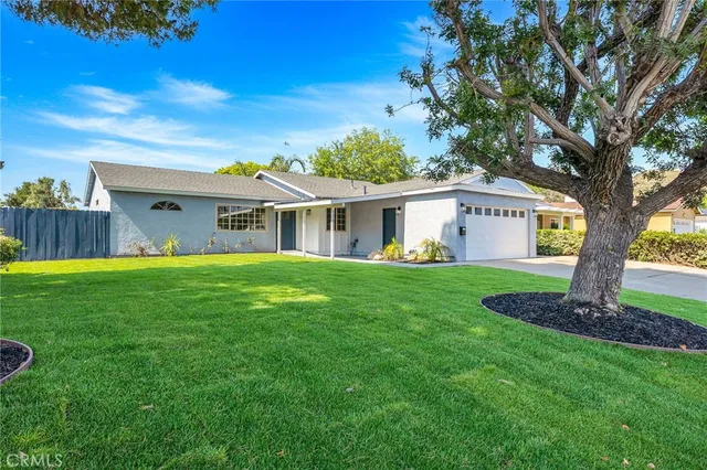 a front view of house with a garden